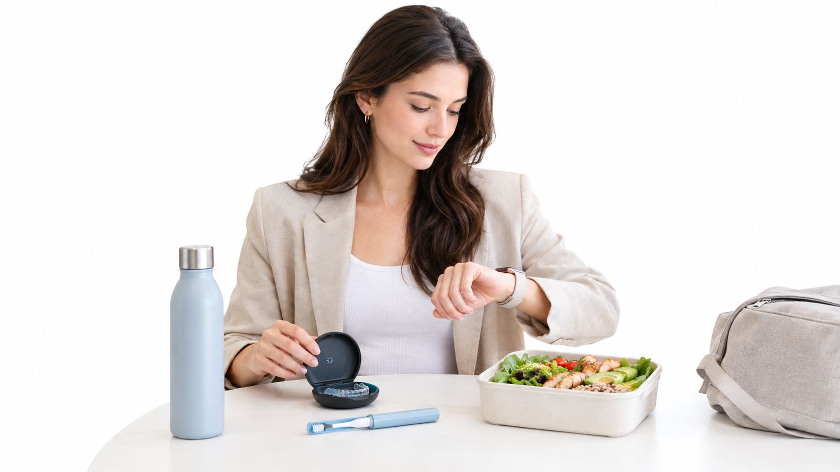 A woman in a blazer checking her watch while preparing to eat a healthy meal with Invisalign.